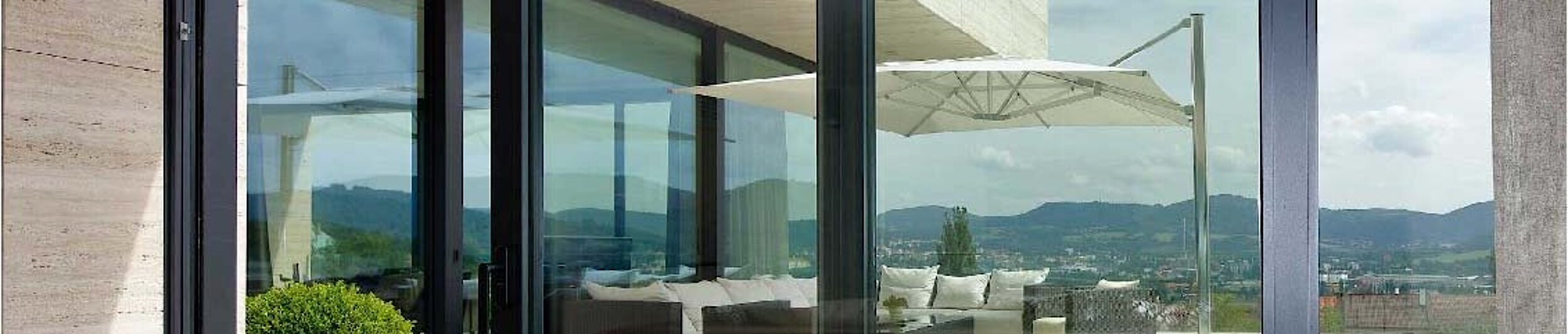 Blick auf eine Dachterrasse durch Alu-Fenster von Schüco